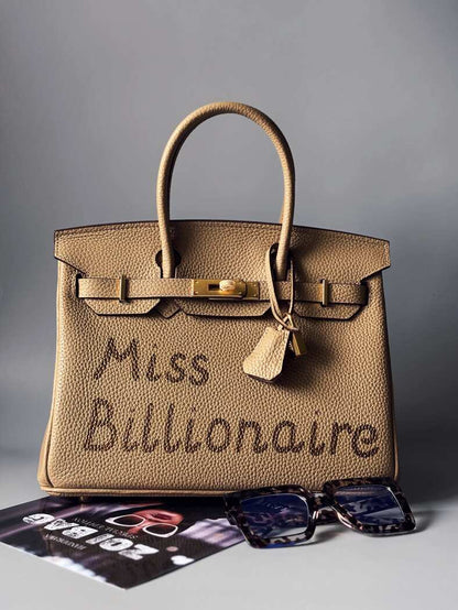 Kožená béžová kabelka Zoi Bag s nápisem "Miss Billionaire" z limitované edice