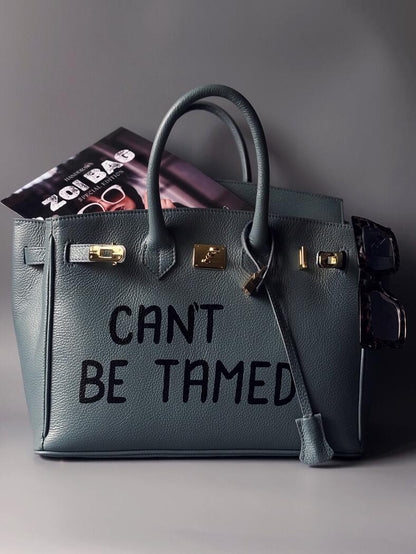 Kožená velká šedomodrá kabelka Zoi Bag s ručně psaným nápisem "Can't be tamed"