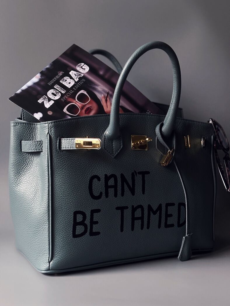 Kožená velká šedomodrá kabelka Zoi Bag s ručně psaným nápisem "Can't be tamed"