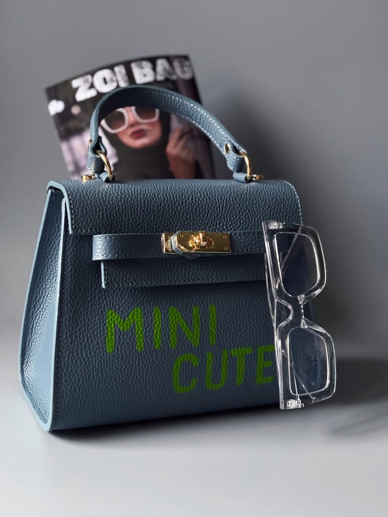 Art kožená kabelka Zoi Bag v modré barvě s nápisem "Mini Cute"