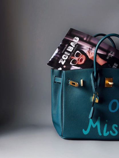 Art modrá kožená kabelka Zoi Bag s nápisem "On a Mission" detail