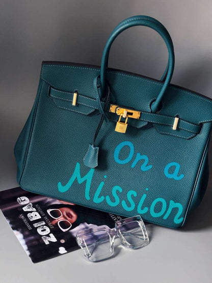 Art modrá kabelka Zoi Bag z kůže s nápisem "On a Mission"