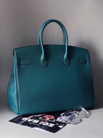 Originální modrá kožená kabelka Zoi Bag s nápisem "On a Mission" zezadu