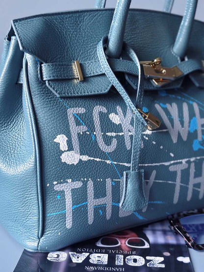 Velká kožená kabelka Zoi Bag v barevné kombinaci modrá a šedá s ručně psaným nápisem "FCK what they think" detail