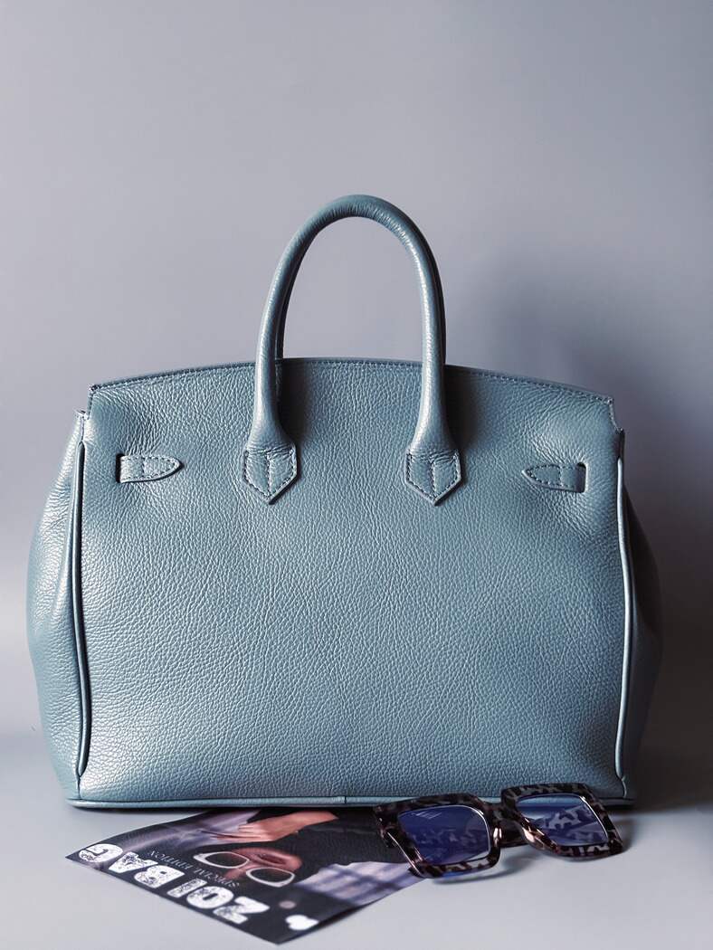 Modrá/šedá kožená kabelka Zoi Bag s ručně psaným nápisem "Can't be tamed" a barevnými cákanci. Zezadu