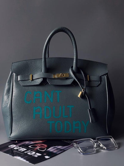 Modrošedá kožená kabelka Zoi Bag s ručně psaným nápisem "Can't adult today" zapnutá