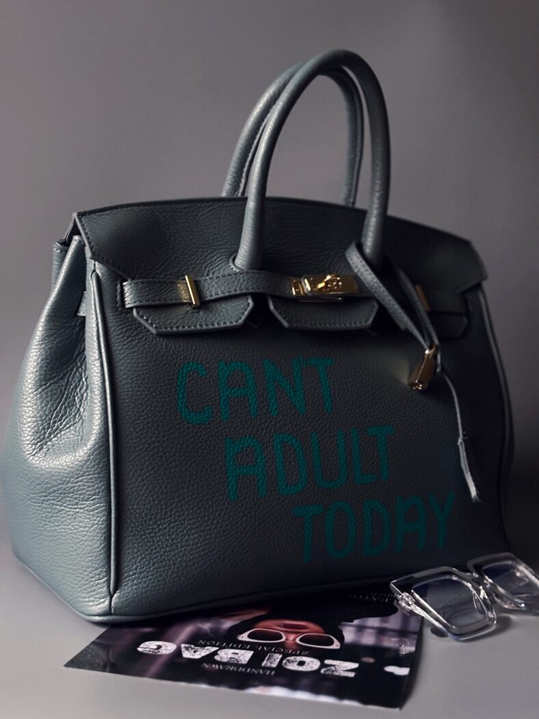 Modrošedá kožená kabelka Zoi Bag s ručně psaným nápisem "Can't adult today" zapnutá z boku