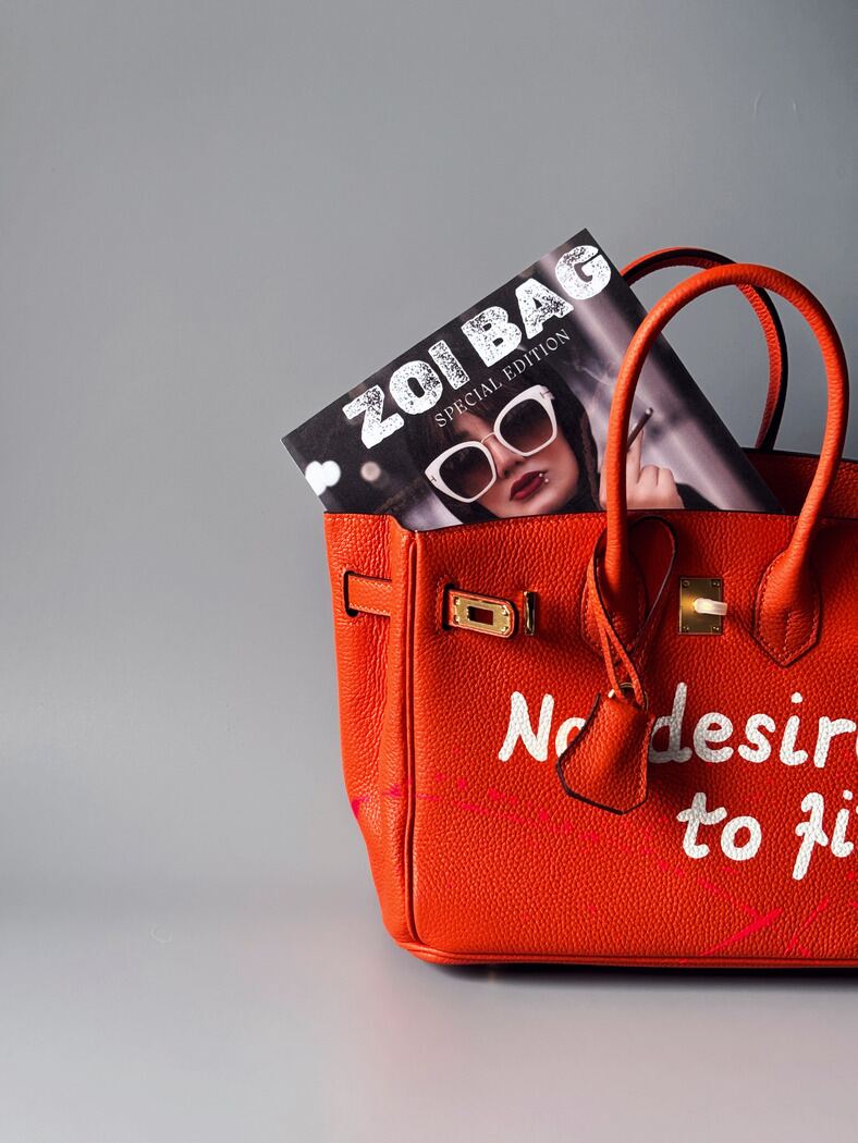 Art kožená kabelka Zoi Bag v oranžové barvě s nápisem "No desire to fit in" detail