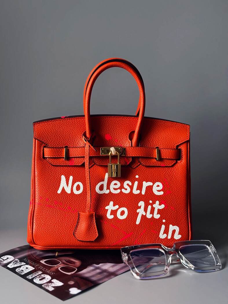 Oranžová designová kožená kabelka Zoi Bag s nápisem "No desire to fit in"