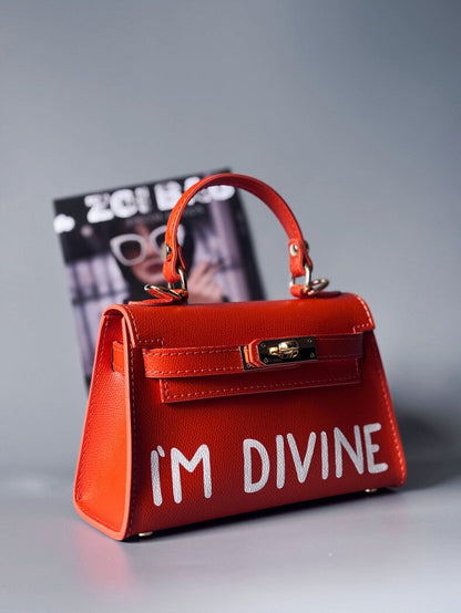 Designová luxusní oranžová kabelka s ručně psaným nápisem, elegantním otočným zámkem a odnímatelným crossbody popruhem.