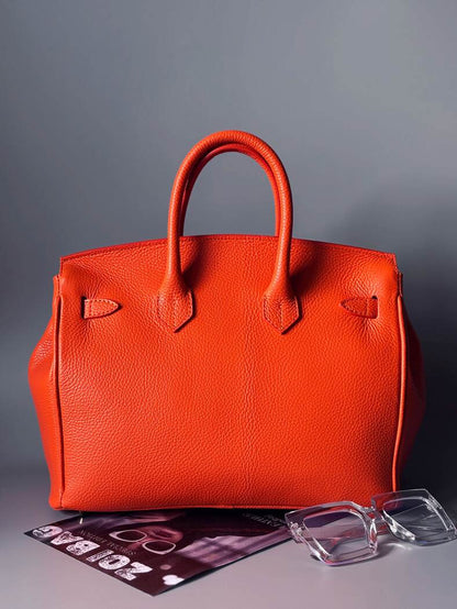 Luxusní designová oranžová kabelka z kvalitní italské pravé kůže s ručně psaným nápisem, zapínání na zámek s klíčkem. Zezadu.