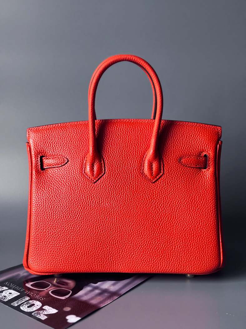 Oranžová kožená kabelka Zoi Bag s ručně psaným nápisem "WTF" a modrými cákanci barvou. Zapínání pomocí zlatého zámku s klíčkem. Zezadu.