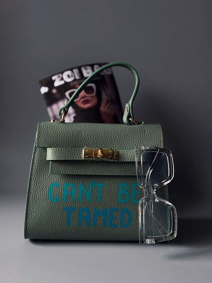 Kožená kabelka Zoi Bag v pistáciové barvě s originálním nápisem "Can't be tamed"