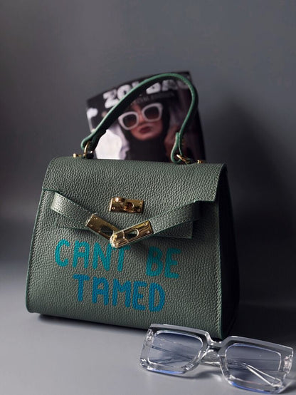 Designová pistáciová kabelka Zoi Bag vyrobená z pravé kůže s nápisem "Can't be tamed"