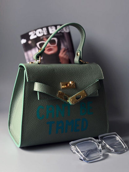 Art pistáciová kabelka Zoi Bag z pravé italské kůže s nápisem "Can't be tamed"