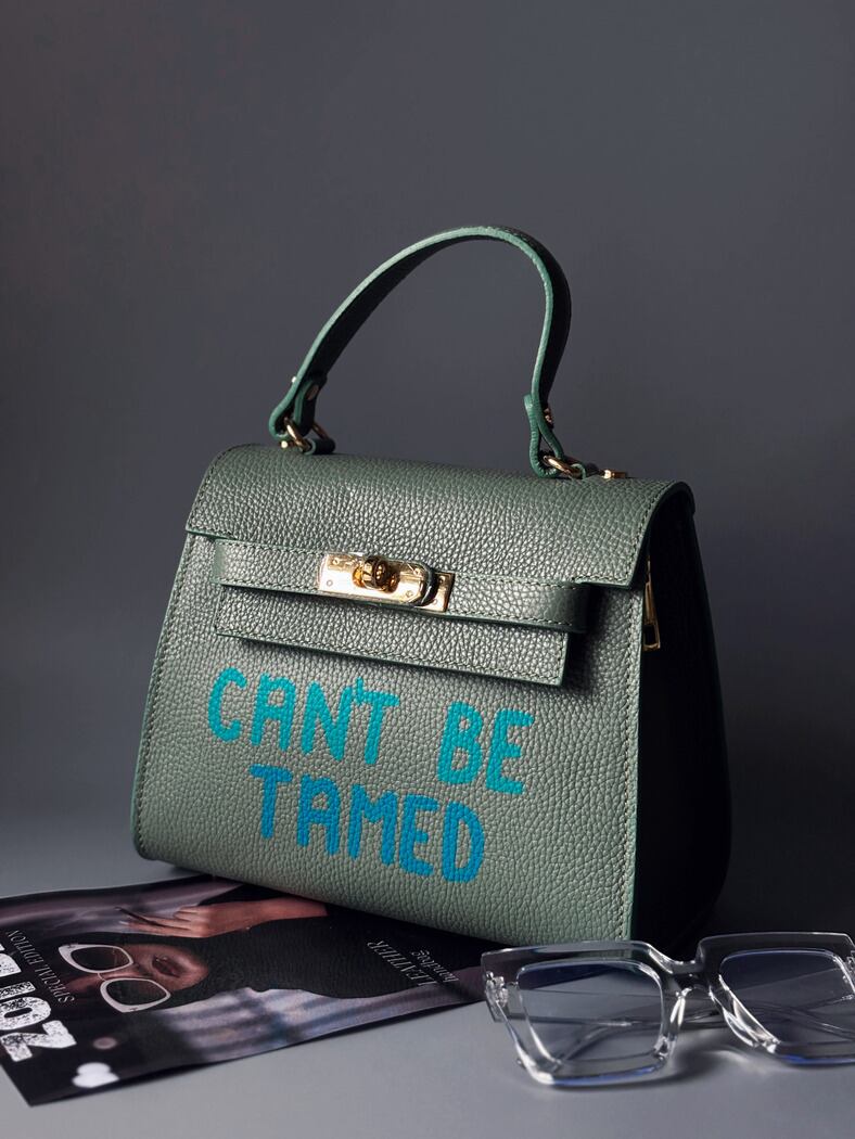 Originální kožená kabelka Zoi Bag v pistáciové barvě s nápisem "Can't be tamed" z boku