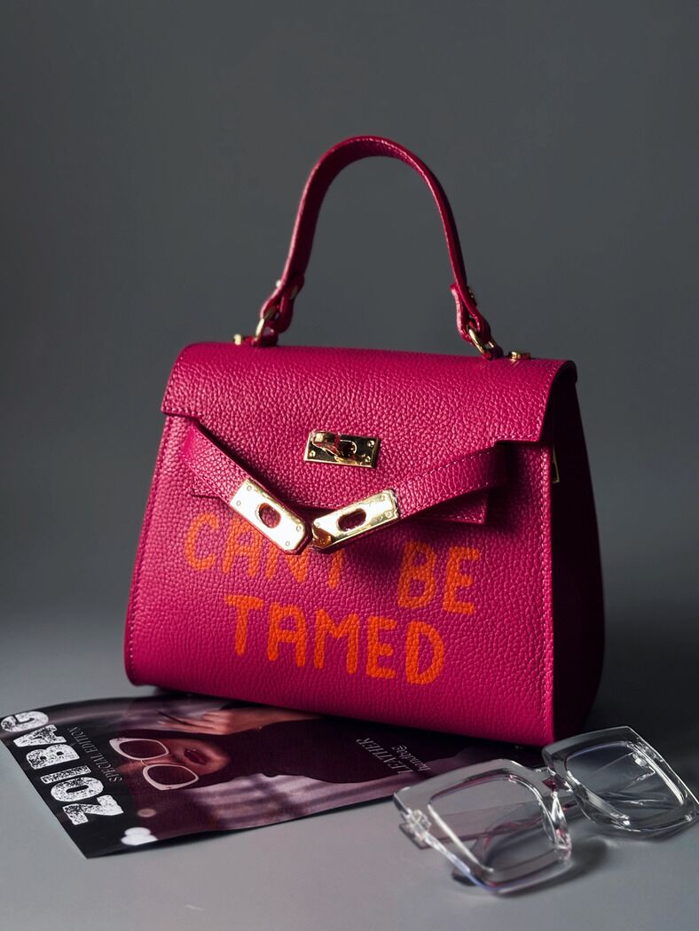 Růžová kožená kabelka Zoi Bag s odvážným nápisem "Can't be tamed"