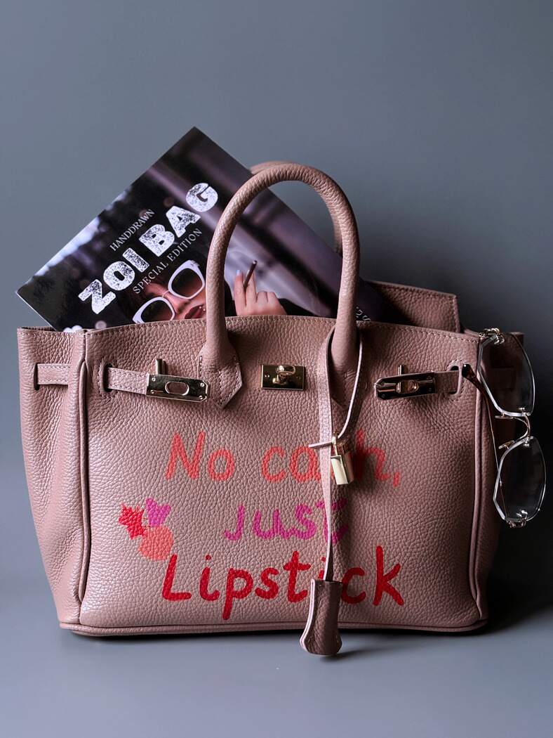 Růžová designová kožená kabelka Zoi Bag s ručně psaným nápisem a cákanci barvou. 