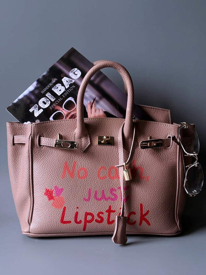 Růžová designová kožená kabelka Zoi Bag s ručně psaným nápisem a cákanci barvou. 