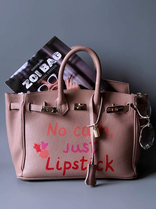 Růžová designová kožená kabelka Zoi Bag s ručně psaným nápisem a cákanci barvou. 