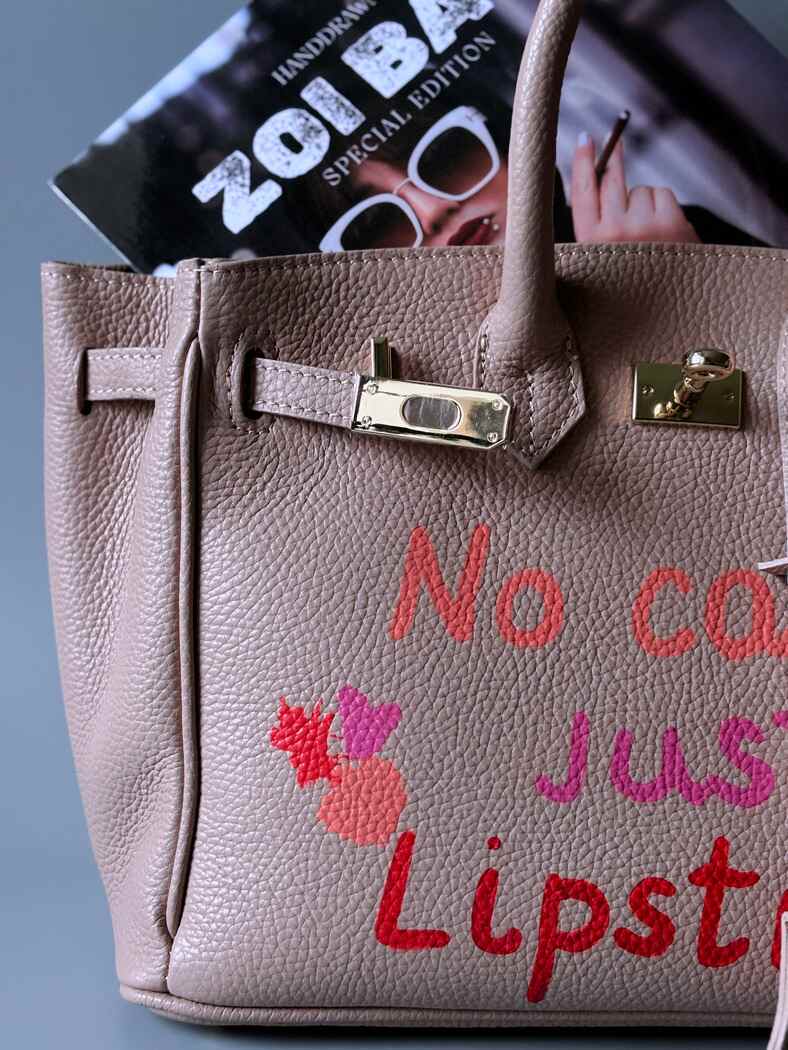 Růžová designová kožená kabelka Zoi Bag s ručně psaným nápisem a cákanci barvou. Detail.