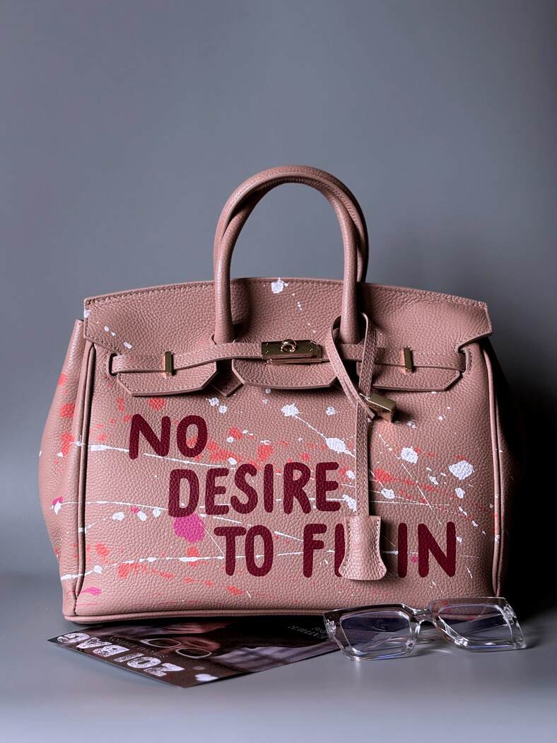 Růžová art designová kožená kabelka Zoi Bag s ručně psaným nápisem a cákanci barvou.  Zapnutá.