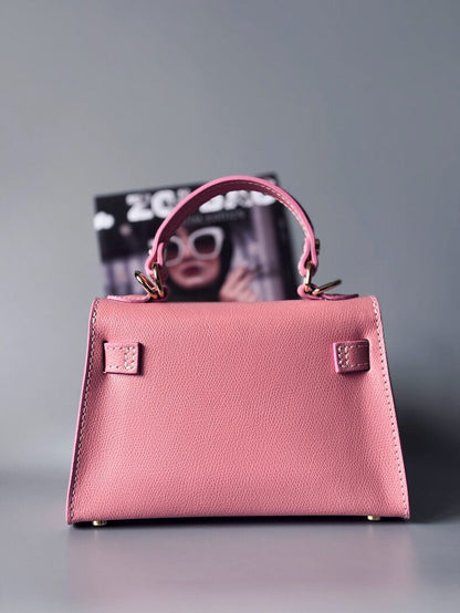 Designová luxusní růžová kabelka s ručně psaným nápisem, elegantním otočným zámkem a odnímatelným crossbody popruhem. Zezadu.