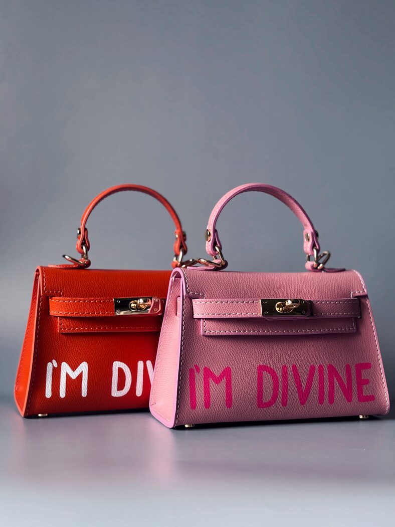 Designová luxusní růžová a oranžová kabelka s ručně psaným nápisem, elegantním otočným zámkem a odnímatelným crossbody popruhem. 