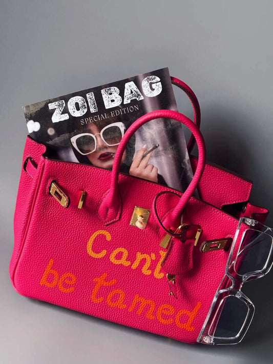 Růžová designová kožená kabelka Zoi Bag s nápisem "Can't be tamed"