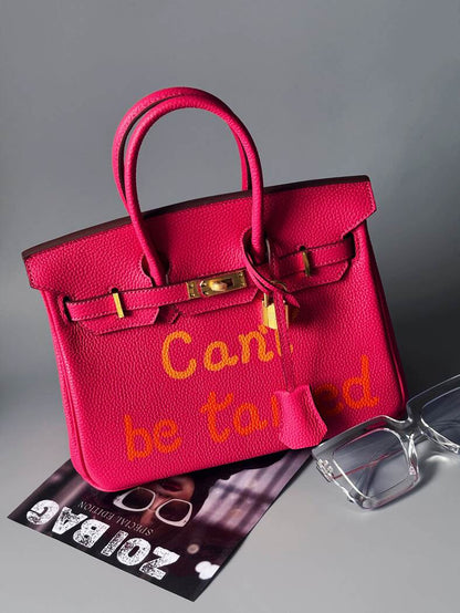 Art růžová kožená kabelka Zoi Bag s nápisem "Can't be tamed"