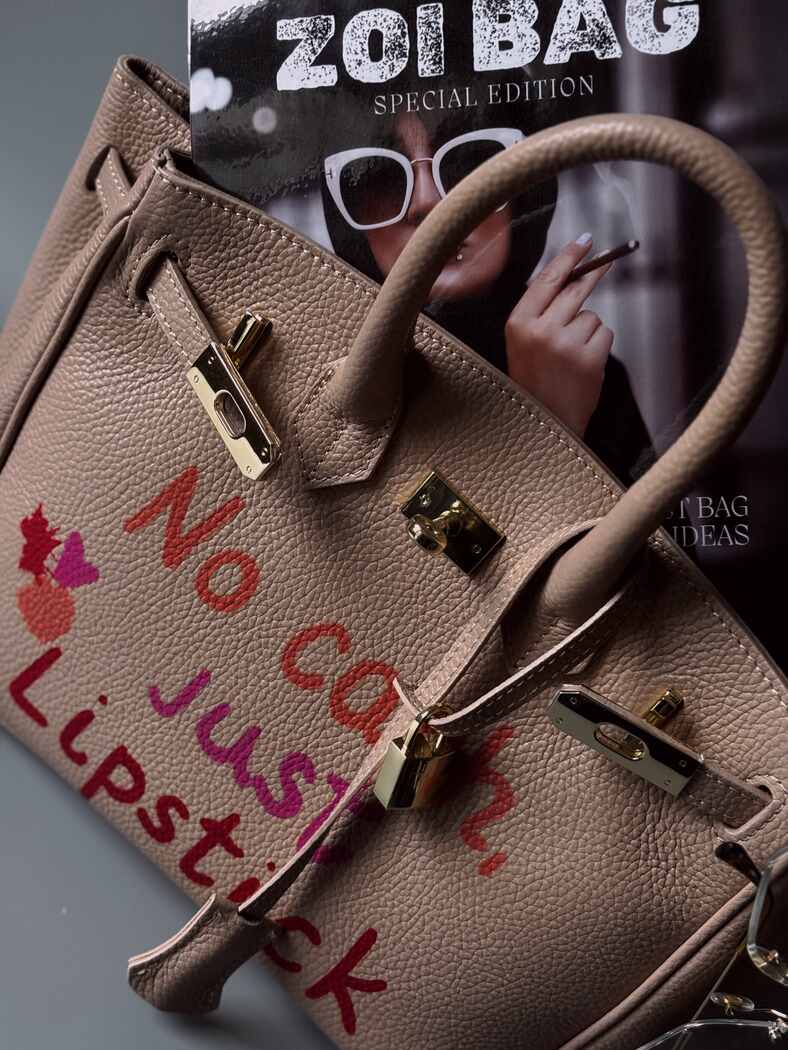 Kožená kabelka Zoi Bag s nápisem "No cash, just lipstick" v růžovo-béžové barvě