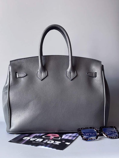 Luxusní designová kabelka vyrobená z kvalitní italské kůže s ručně psaným nápisem a cákanci barvou. Ikonické zapínání na zámek s klíčkem. Zezadu.