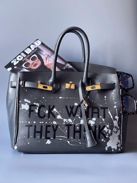 Designová luxusní šedá kožená kabelka Zoi Bag s ručně psaným nápisem a s cákanci barvou. Zapínání pomocí klíčku a zámku.