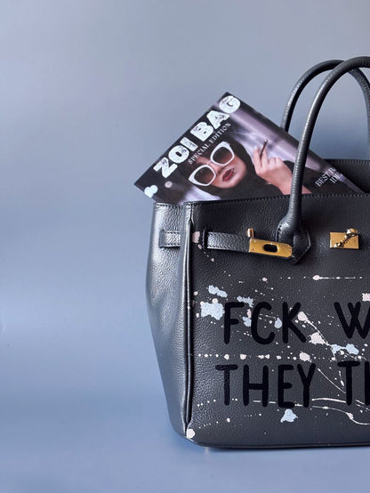 Designová luxusní šedá kožená kabelka Zoi Bag s ručně psaným nápisem a s cákanci barvou. Zapínání pomocí klíčku a zámku. Detail.