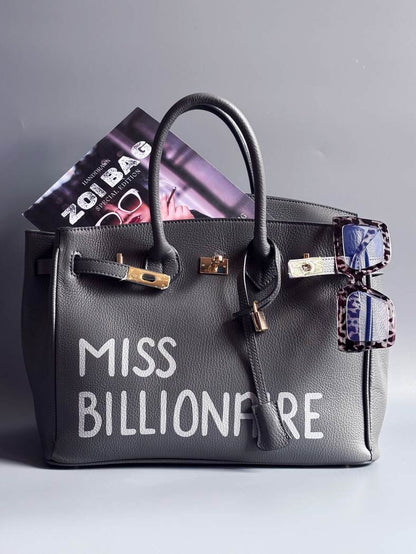 Šedá kožená kabelka Zoi Bag vyrobená z kvalitní italské kůže, s ručně psaným nápisem a se zámkem a klíčkem. Pro personalizaci na zakázku.