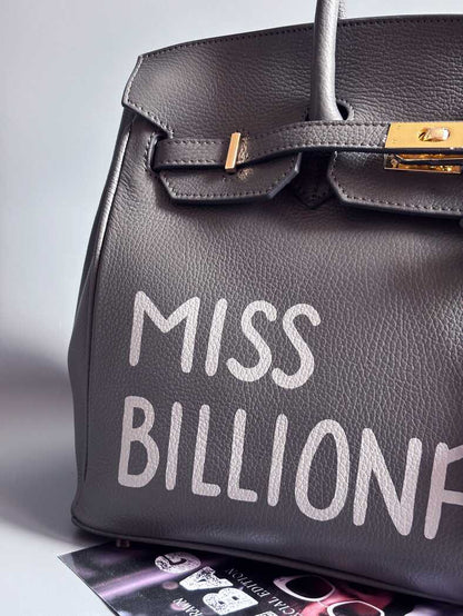 Šedá kožená kabelka Zoi Bag vyrobená z kvalitní italské kůže, s ručně psaným nápisem a se zámkem a klíčkem. Pro personalizaci na zakázku. Detail nápisu.