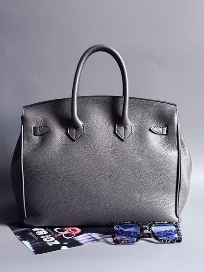 Šedá kožená kabelka Zoi Bag vyrobená z kvalitní italské kůže, s ručně psaným nápisem a se zámkem a klíčkem. Pro personalizaci na zakázku. Zezadu.