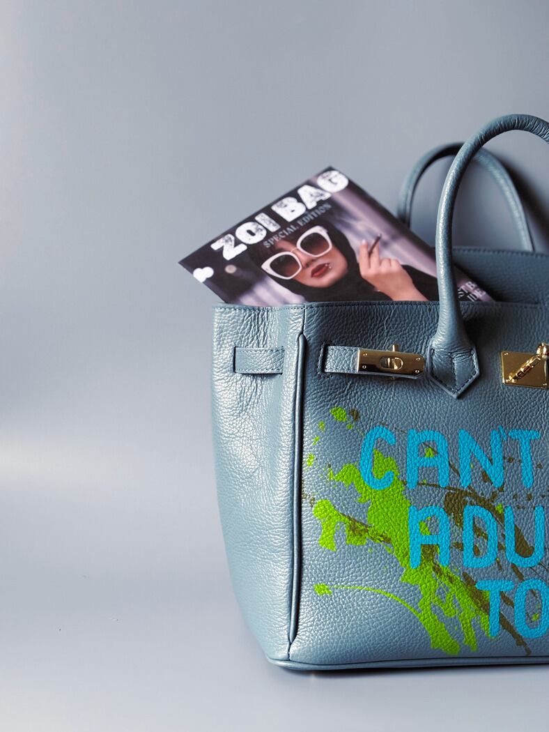 Šedá/modrá velká kožená kabelka Zoi Bag s ručně psaným nápisem "Can't adult today" a barevnými cákanci. Zlatý zámek s klíčkem.