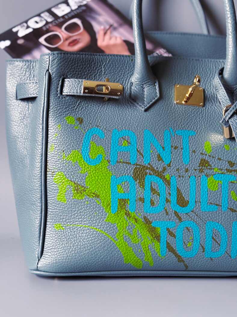 Šedá/modrá velká kožená kabelka Zoi Bag s ručně psaným nápisem "Can't adult today" a barevnými cákanci. Zlatý zámek s klíčkem.