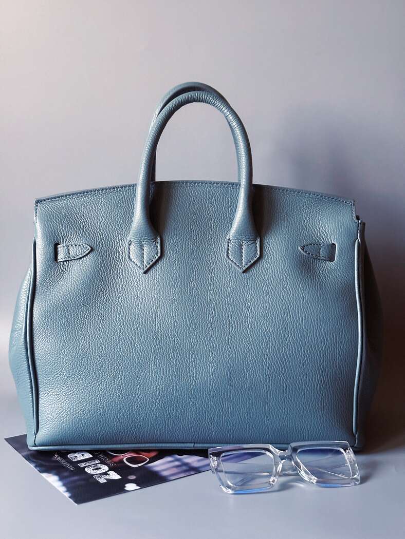 Velká kožená kabelka Zoi Bag v barevných tónech šedé a modré s ručně psaným bílým nápisem "FCK what they think" zezadu