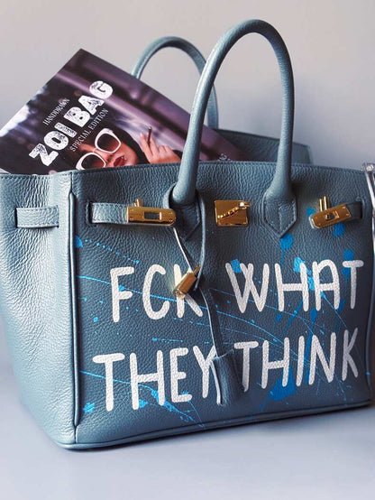 Velká kožená kabelka Zoi Bag v barevných tónech šedé a modré s ručně psaným bílým nápisem "FCK what they think"