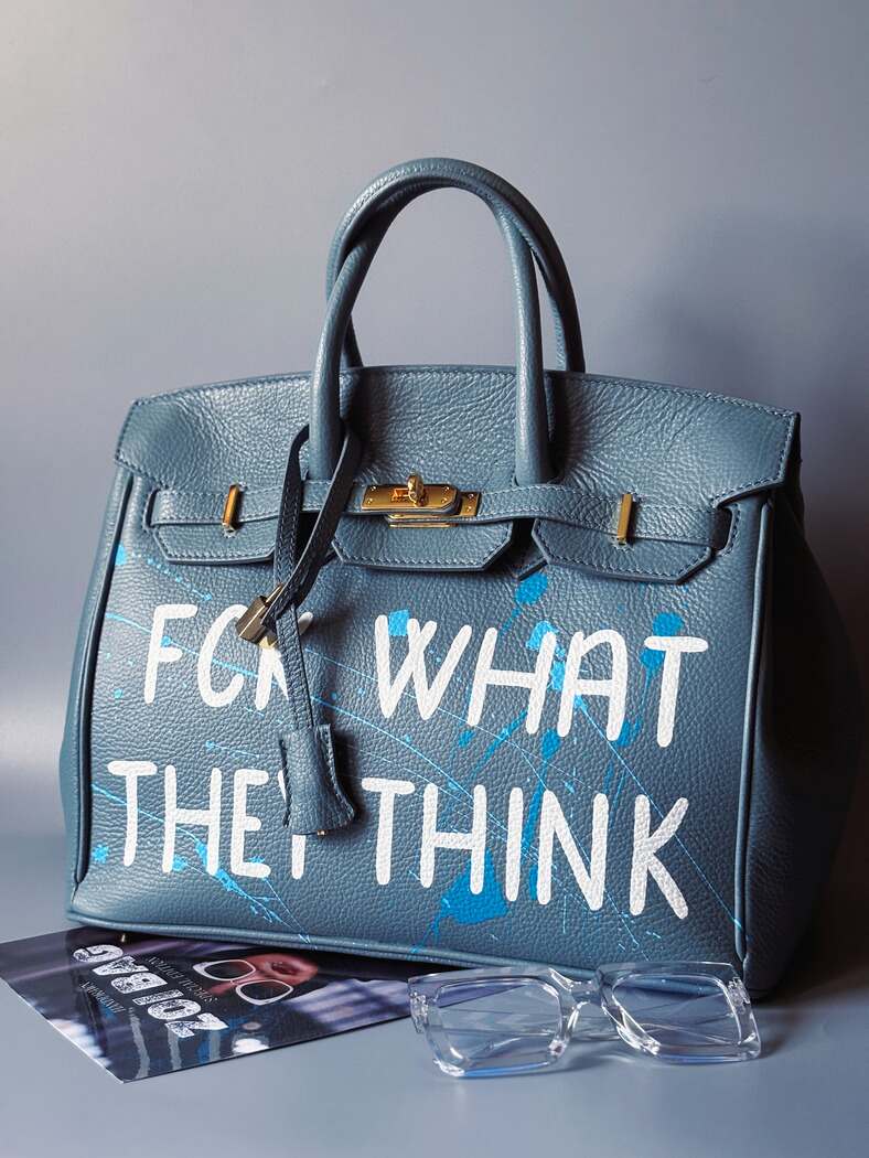 Velká kožená kabelka Zoi Bag v barevných tónech šedé a modré s ručně psaným bílým nápisem "FCK what they think"