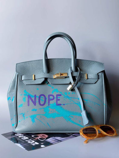 Velká šedomodrá tote kožená kabelka Zoi Bag s ručně psaným nápisem, designová art kabelka. Zapnutá.