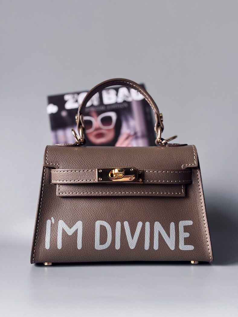 Designová luxusní tmavě béžová kabelka s ručně psaným nápisem, elegantním otočným zámkem a odnímatelným crossbody popruhem.