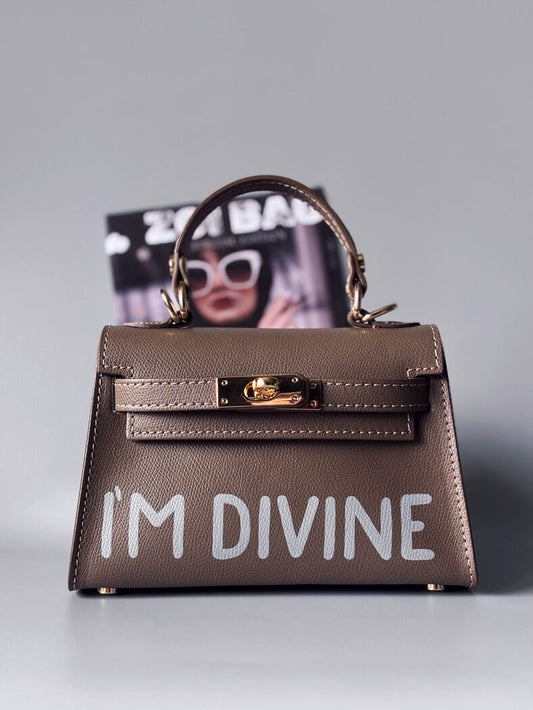 Designová luxusní tmavě béžová kabelka s ručně psaným nápisem, elegantním otočným zámkem a odnímatelným crossbody popruhem.