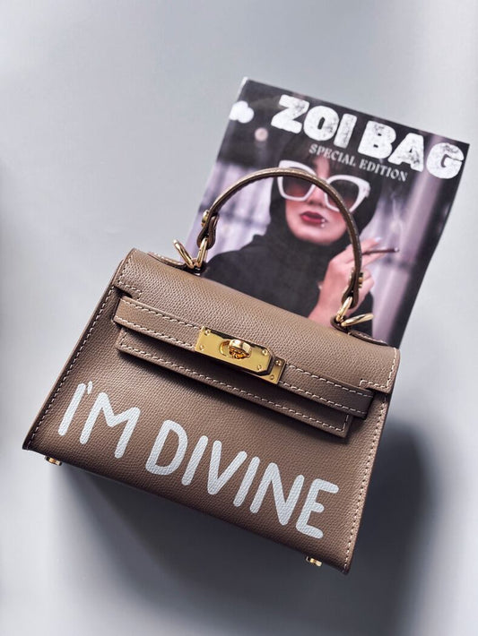 Designová luxusní tmavě béžová kabelka s ručně psaným nápisem, elegantním otočným zámkem a odnímatelným crossbody popruhem.