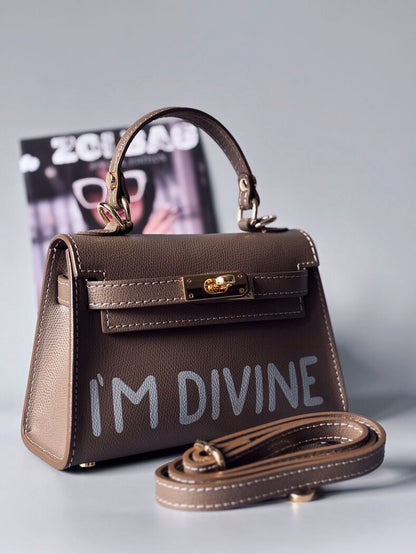 Designová luxusní tmavě béžová kabelka s ručně psaným nápisem, elegantním otočným zámkem a odnímatelným crossbody popruhem.