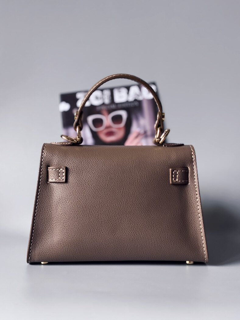 Designová luxusní tmavě béžová kabelka s ručně psaným nápisem, elegantním otočným zámkem a odnímatelným crossbody popruhem. Zezadu.