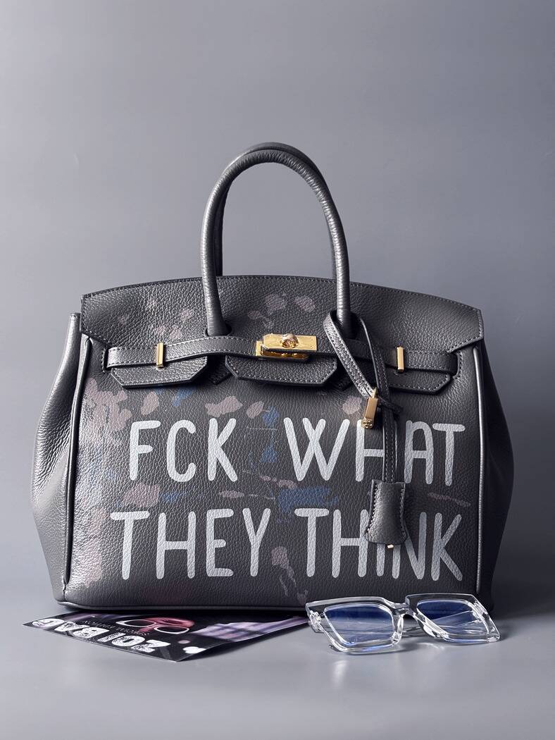 Luxusní art kožená kabelka Zoi Bag s ručně psaný nápisem a cákanci barvou. Ikonické zapínaní na zámek a klíček. Zapnutá.