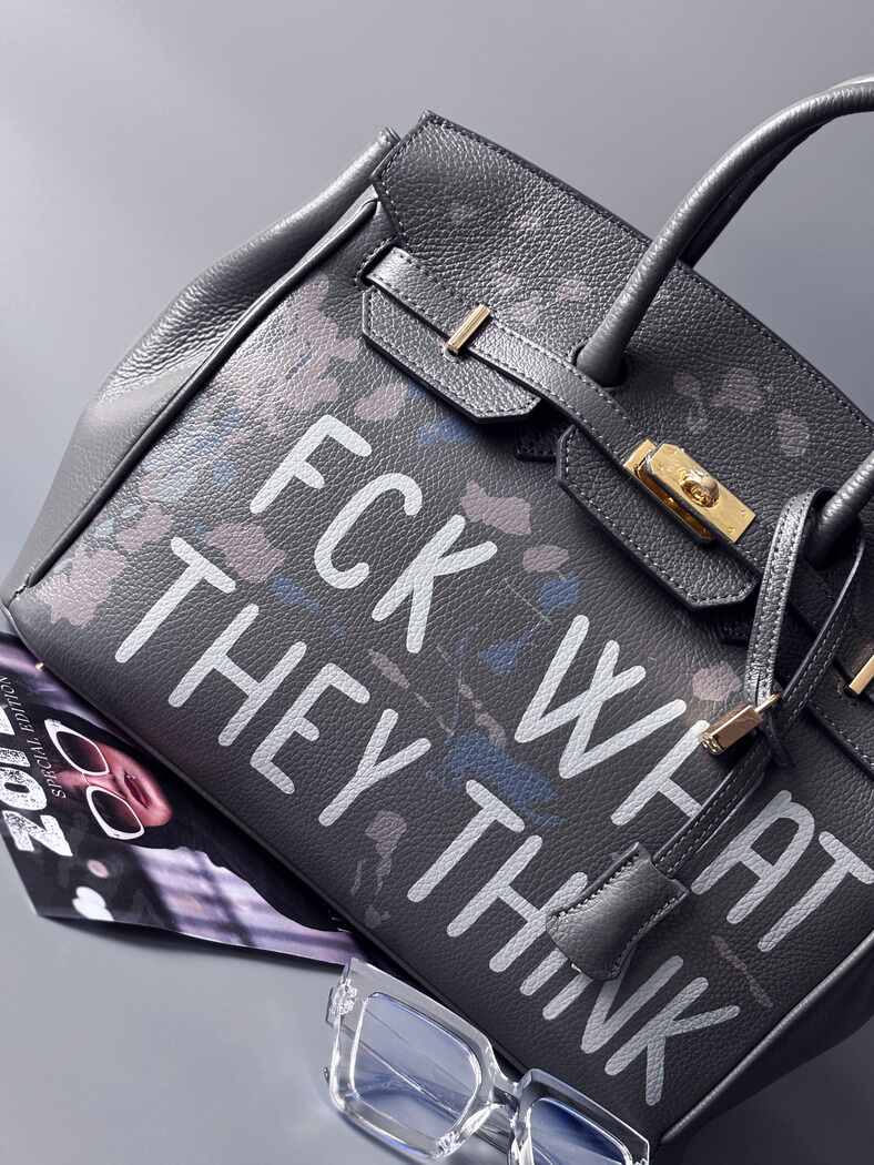 Luxusní art kožená kabelka Zoi Bag s ručně psaný nápisem a cákanci barvou. Ikonické zapínaní na zámek a klíček. Zapnutá.